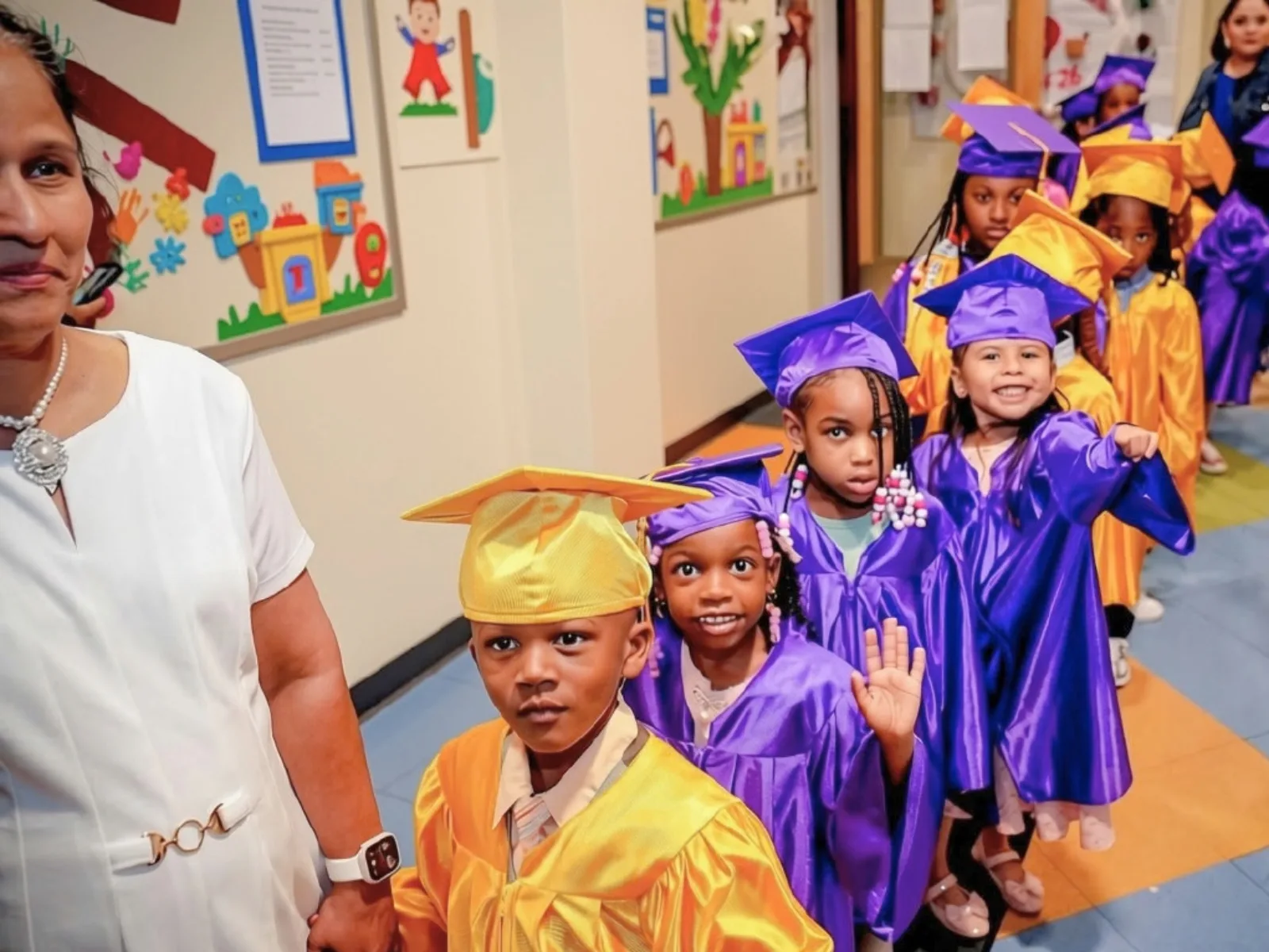 Graduates in purple and gold gowns line up for the ceremony